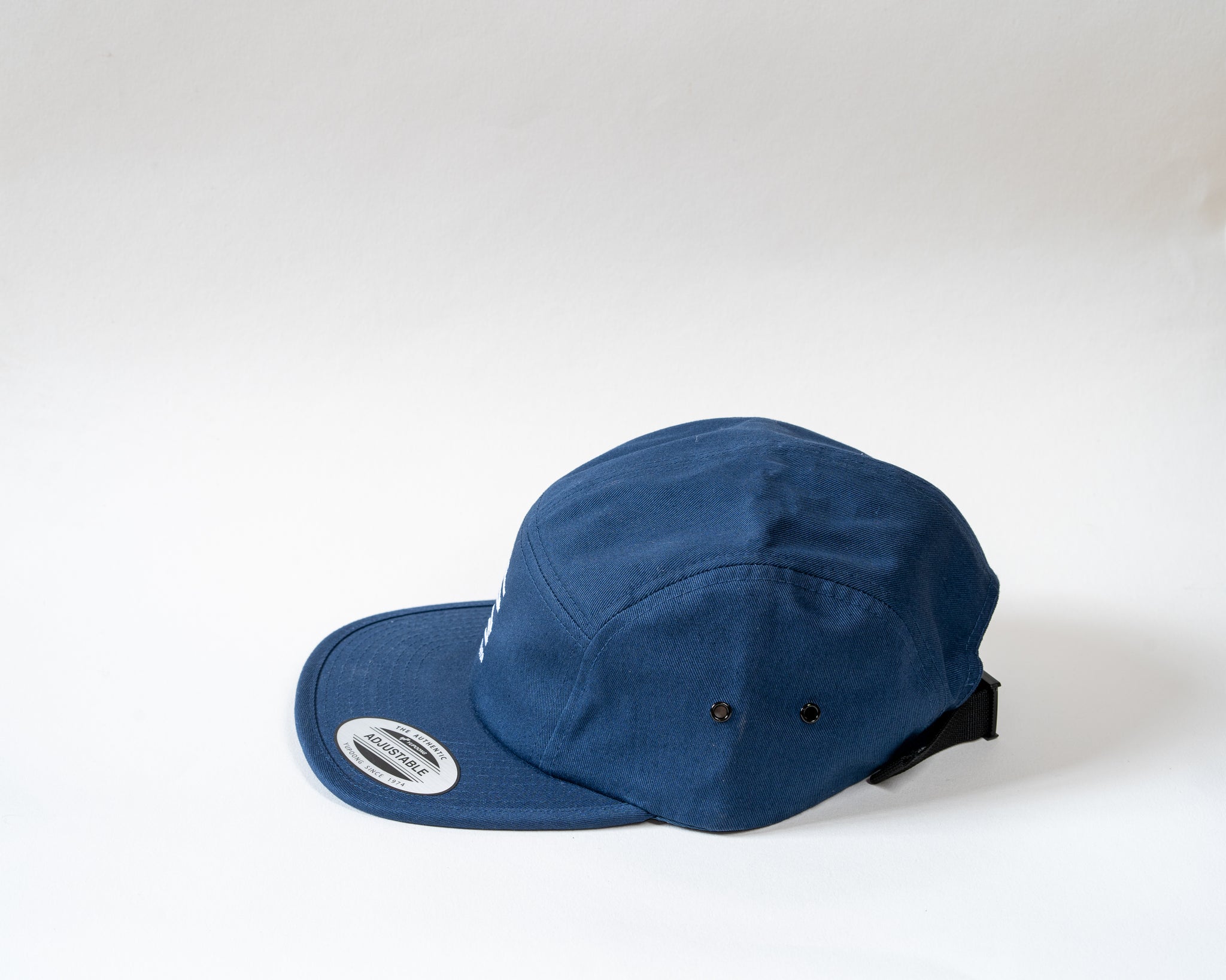 Navy 5 panel cap showcasing the side on a white background