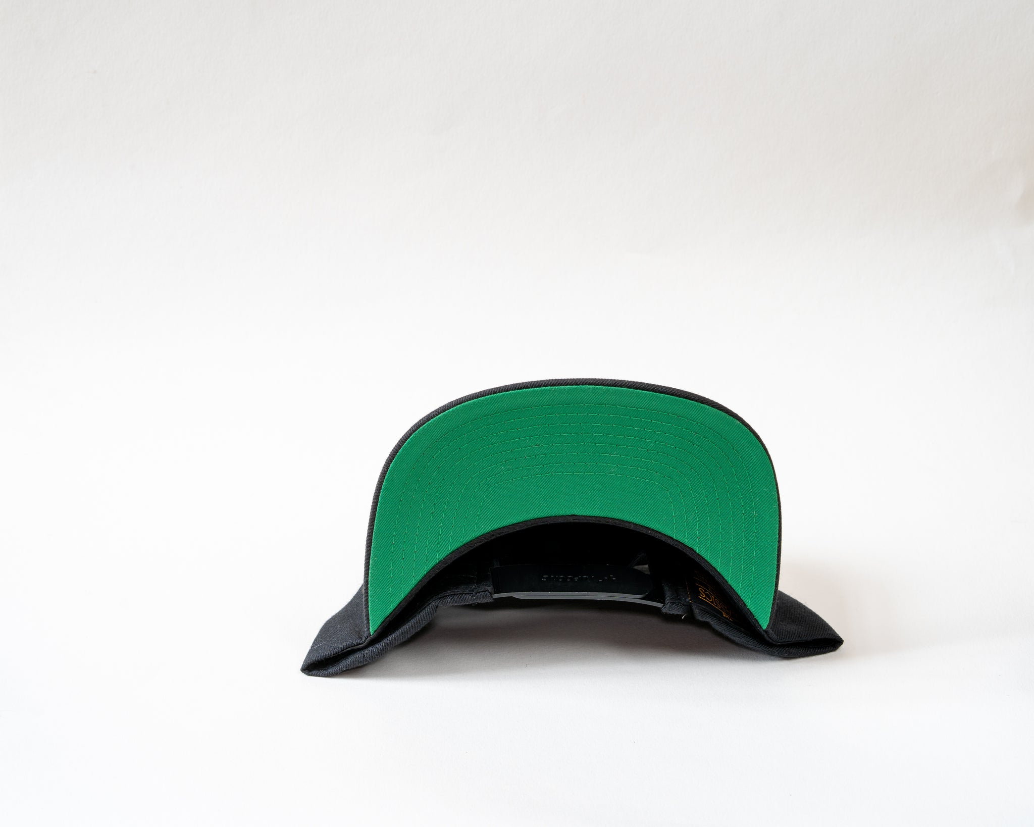 Jam Snapback cap showcasing green base sitting on a white background cool product photography