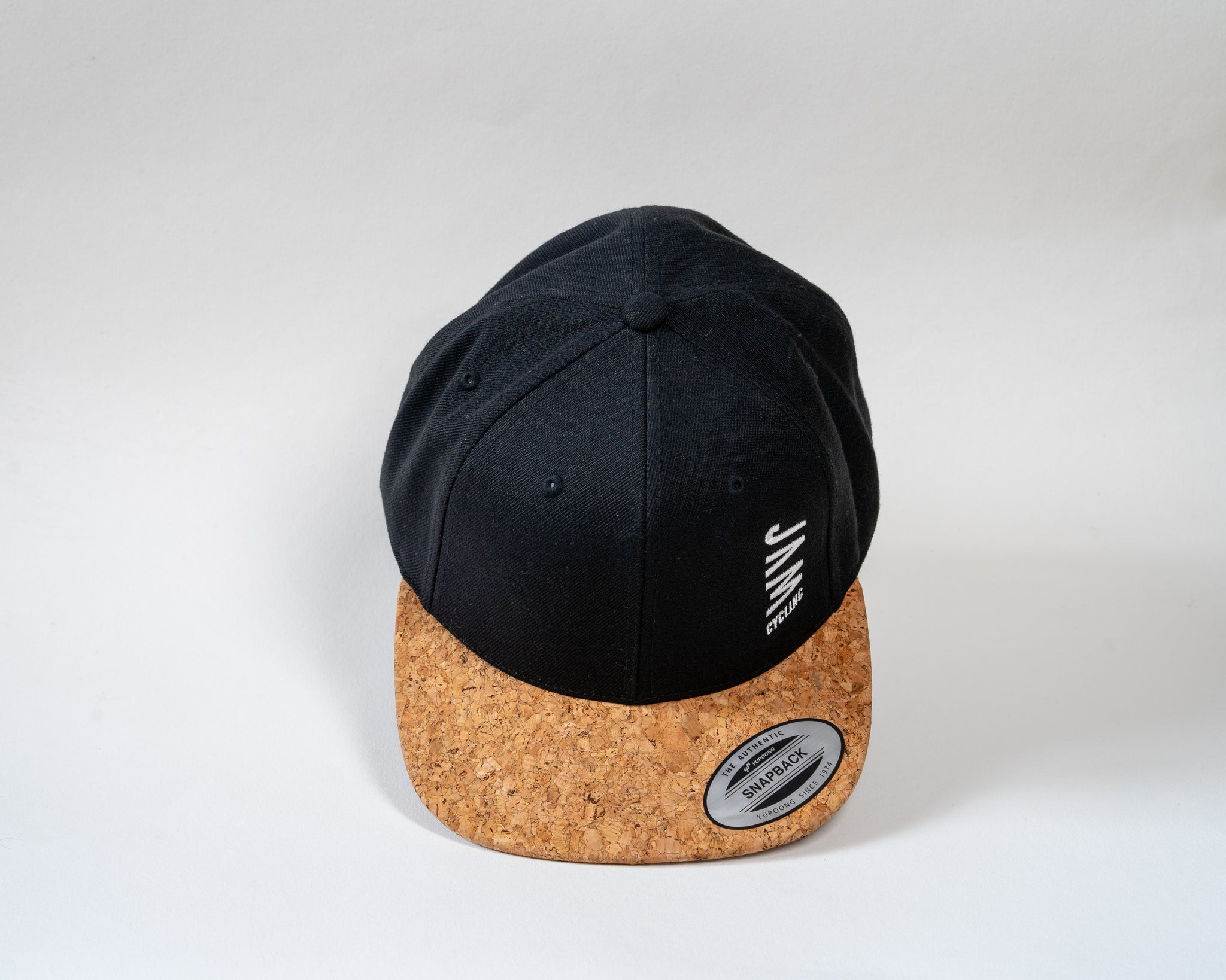 JAM snap back cap featuring cork peak stitched JAM logo floating on a white background