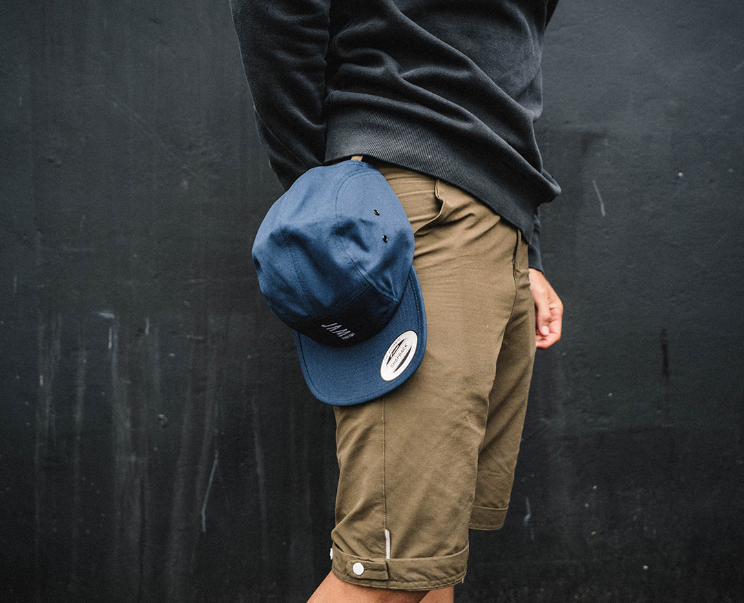 Navy 5 panel cap hanging from the belt of a Jam employee