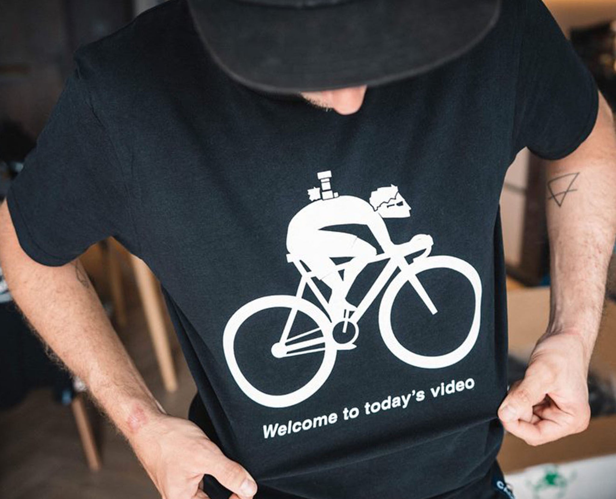 T-shirt showing cartoon cyclist with camera on his back saying "Welcome to todays video" by Francis CADE